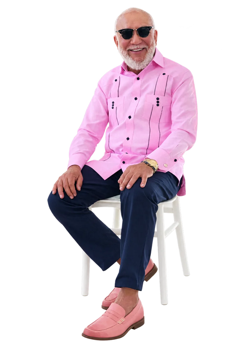Jochy Santos sentado en una silla blanca con chacabana rosa CALPO